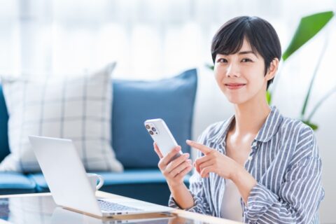 スマートフォンとノートパソコンで公開記事を確認する人物