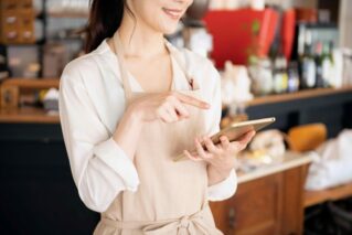 費用の計算をするカフェ店員の女性